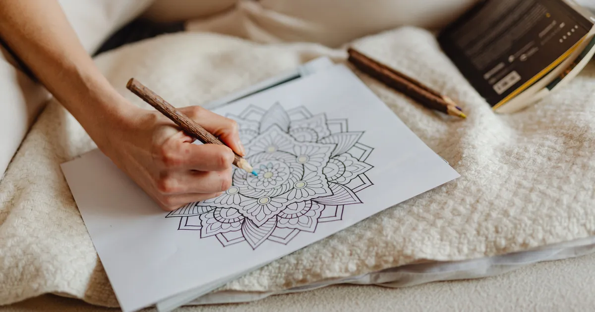 Volwassene kleurt een mandala met kleurpotloden